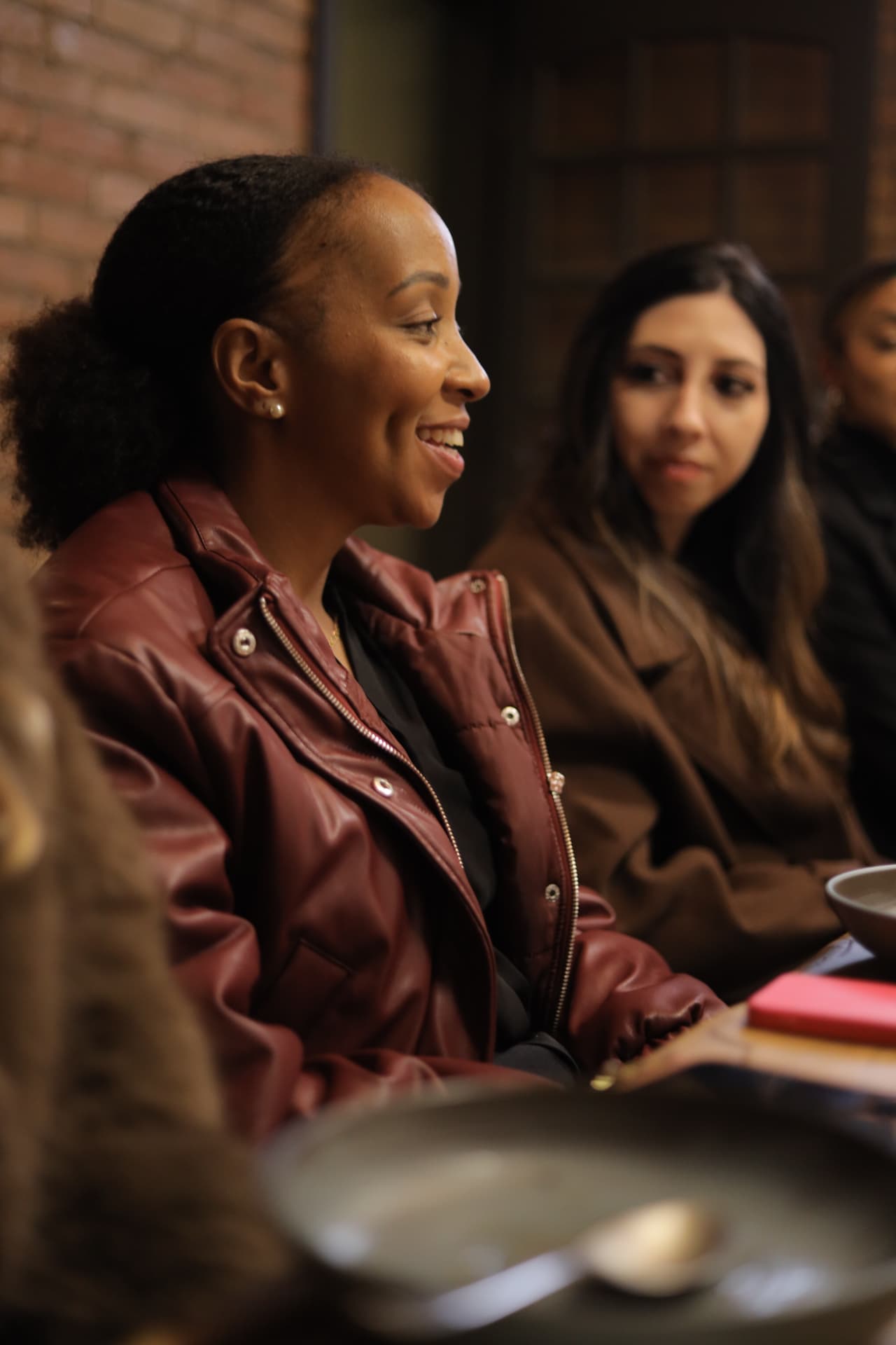 Convidada sorrindo durante a conversa à mesa